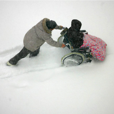 Pushing a wheelchair in the snow