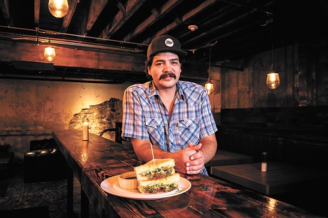 Chef CJ Callahan at Hogwash Whiskey Den with the bar's grilled cheese sandwich.