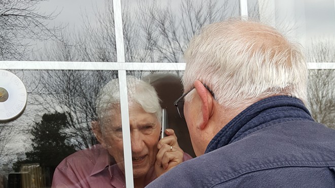 Image: A father sees his son for the final time through a pane of glass at a Lewiston nursing home